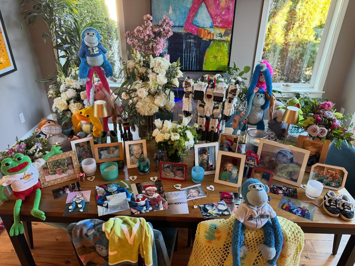 A memorial table filled with blue monkeys, flowers, photos of Finn, and keepsakes from loved ones